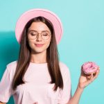 甘いものを手に持つ女性