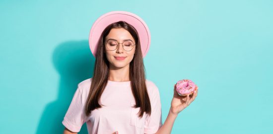 甘いものを手に持つ女性