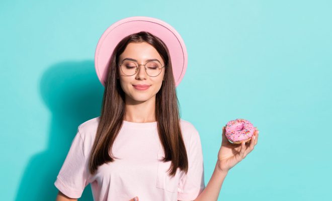 甘いものを手に持つ女性